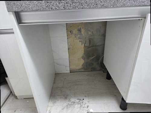 부산 중구 누수탐지 싱크대 하부장 안쪽 배수관과 물자국을 확인하는 모습